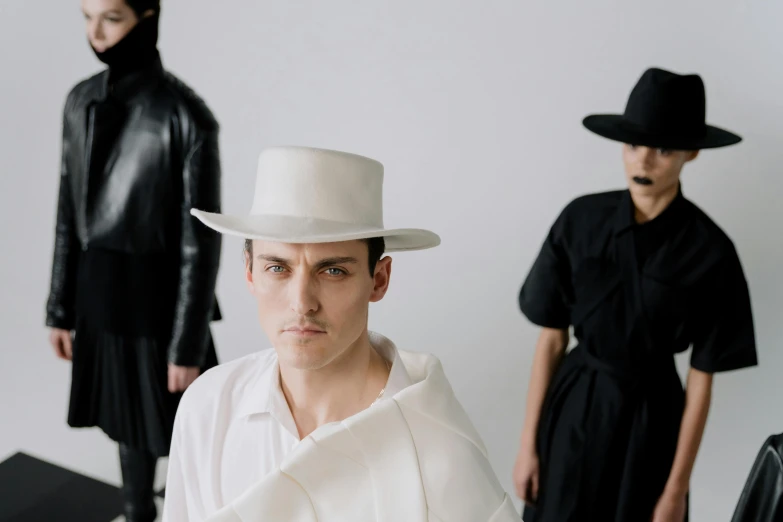 three people standing with hats on