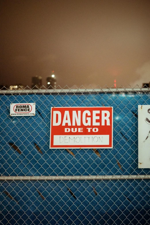 a fence with signs and a sign that says danger due to an airplane