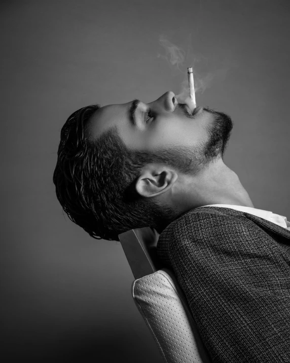 a man with a cigarette in his mouth looking up