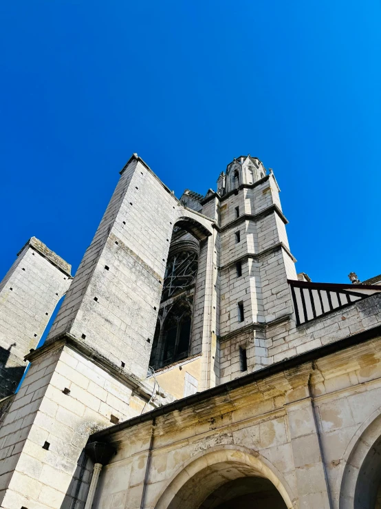 a large gray building with arches and a clock