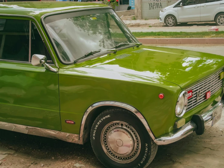 a green old - timey car parked in a residential neighborhood