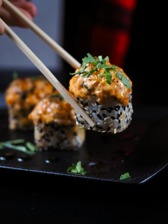 a person holding chopsticks above an appetizer