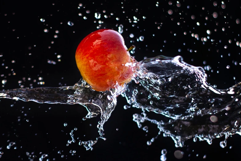 an apple falling in the water and splashing