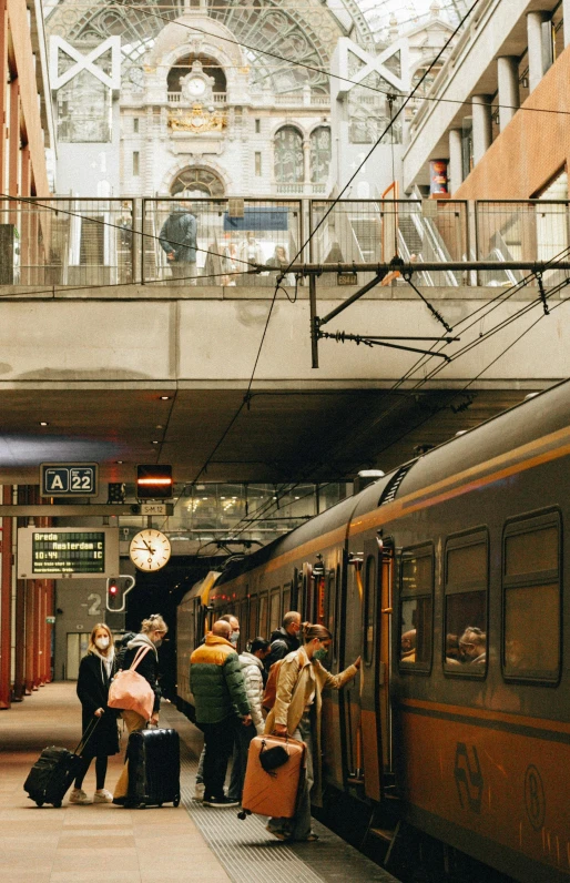 a group of people with luggage next to a train