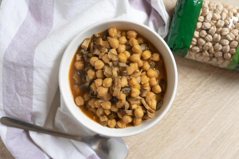 a bowl filled with corn in front of a bottle