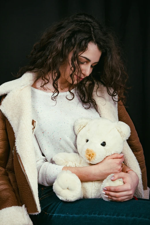 a  is holding a stuffed teddy bear