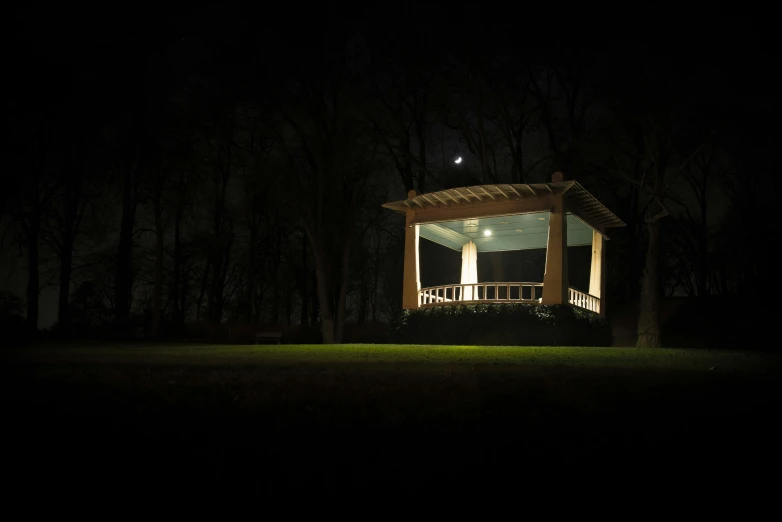 the gazebo is lit up at night in the dark