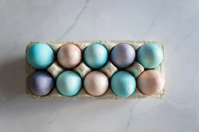 the easter egg in the carton is colored turquoise, pink and purple