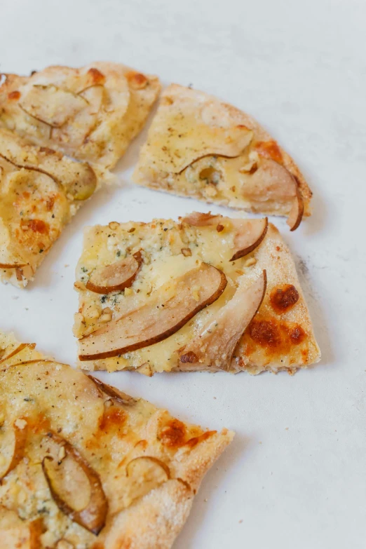 slices of pizza sit in the middle of a white surface