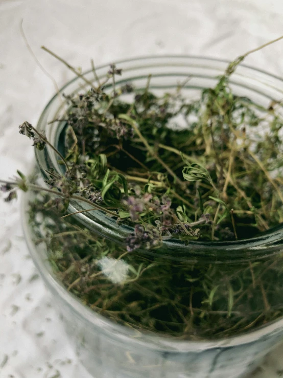 a glass jar full of leaves and flowers