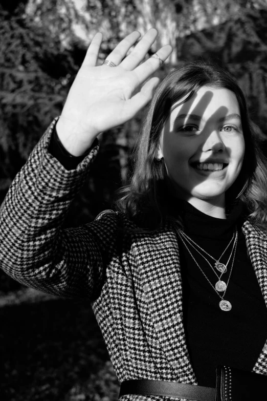 black and white po of woman in business outfit holding her hands up to her face