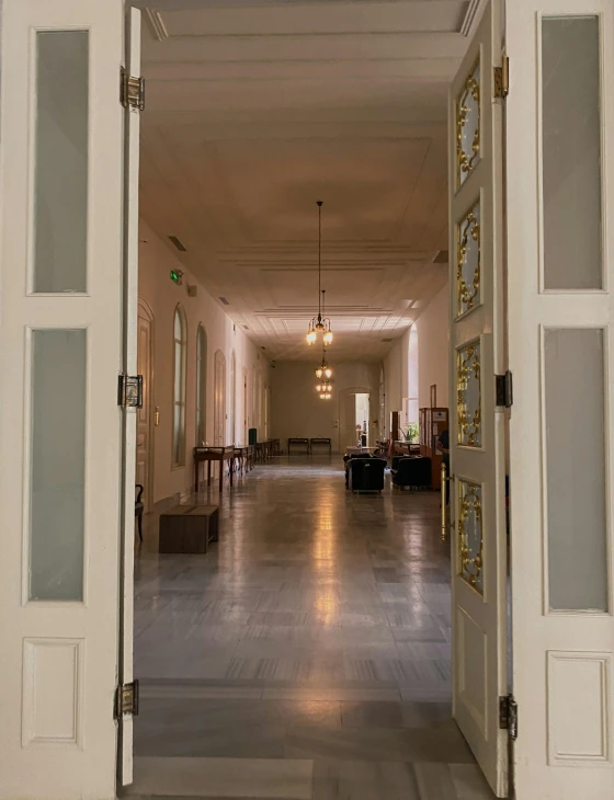 an open doorway leading to a large hall with a bunch of windows