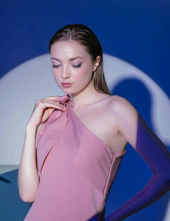 a beautiful woman posing in a pink one shoulder dress