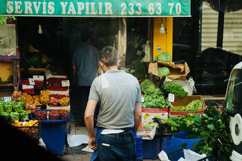 a man is looking at his produce stall