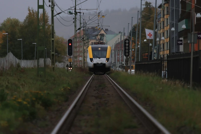 a train traveling down train tracks under power lines