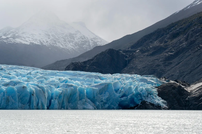 the side of a mountain that has some ice on it