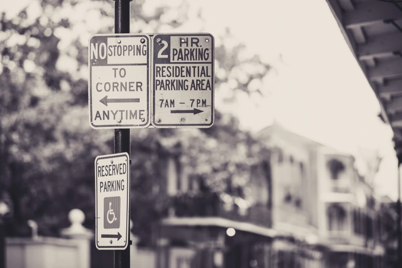 black and white image of parking signs near buildings