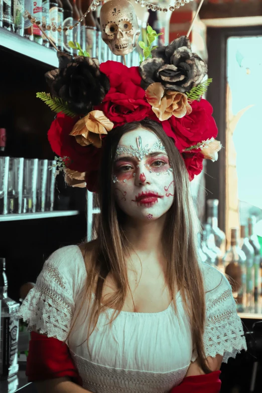 a woman wearing white makeup and flowers on her head