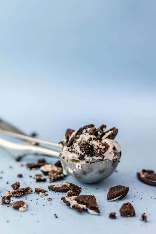 a spoon and a scoop of ice cream are spilled over some cookies