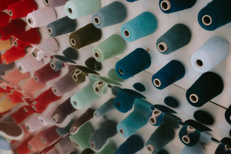 a rack of colorful rolls of thread sitting on top of a table