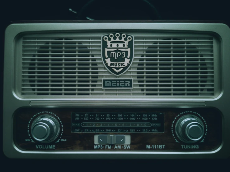 a radio is set on a table, displaying the time and logo