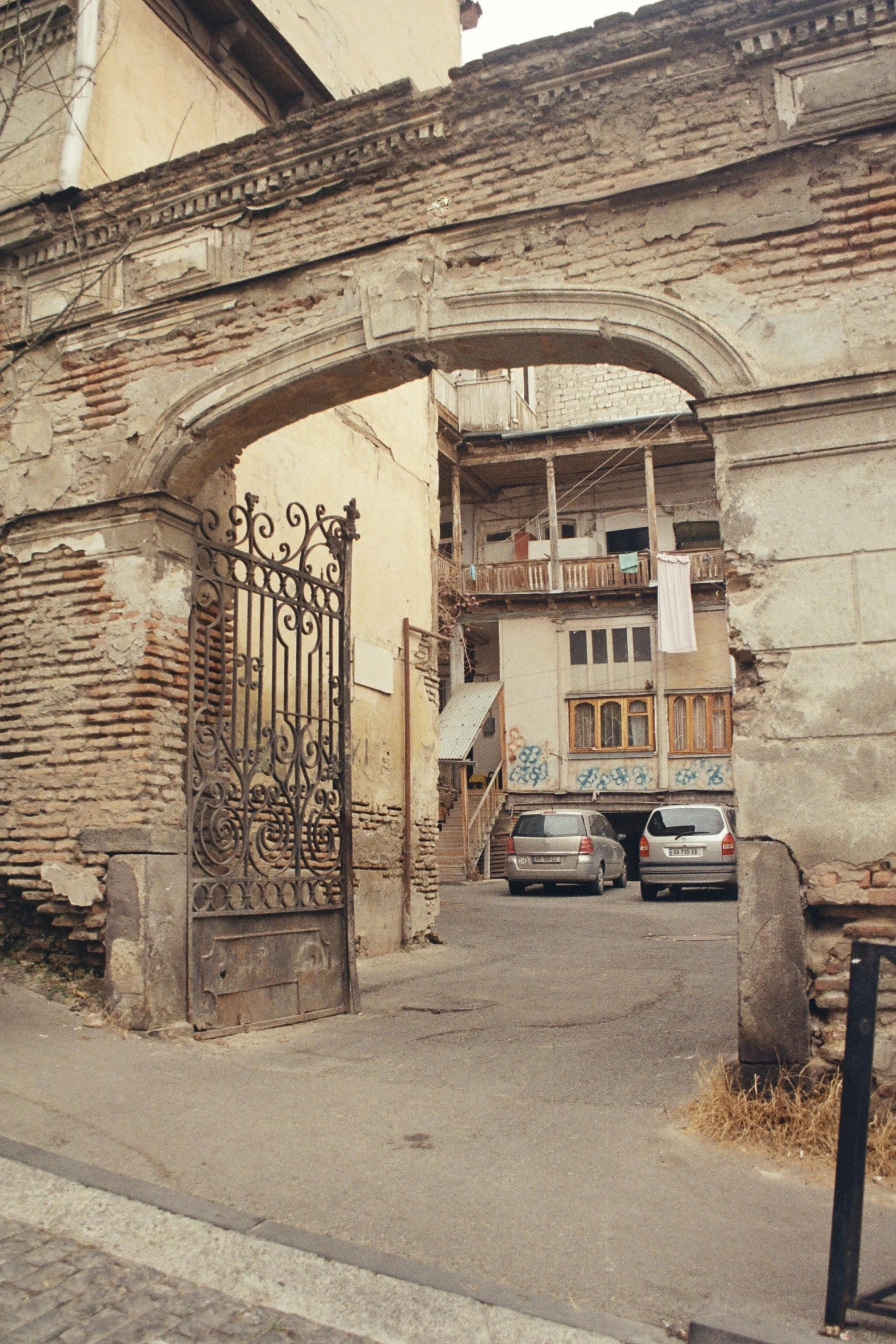 two cars are parked at the entrance to an old building