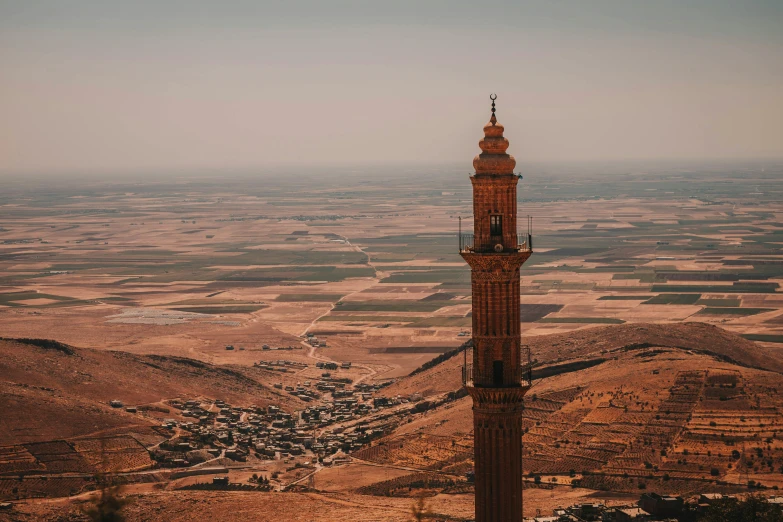 the tower of a mosque is in the middle of a desert