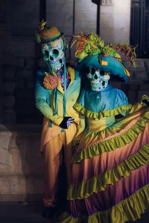 two skeleton men wearing a colorful outfit and standing next to each other