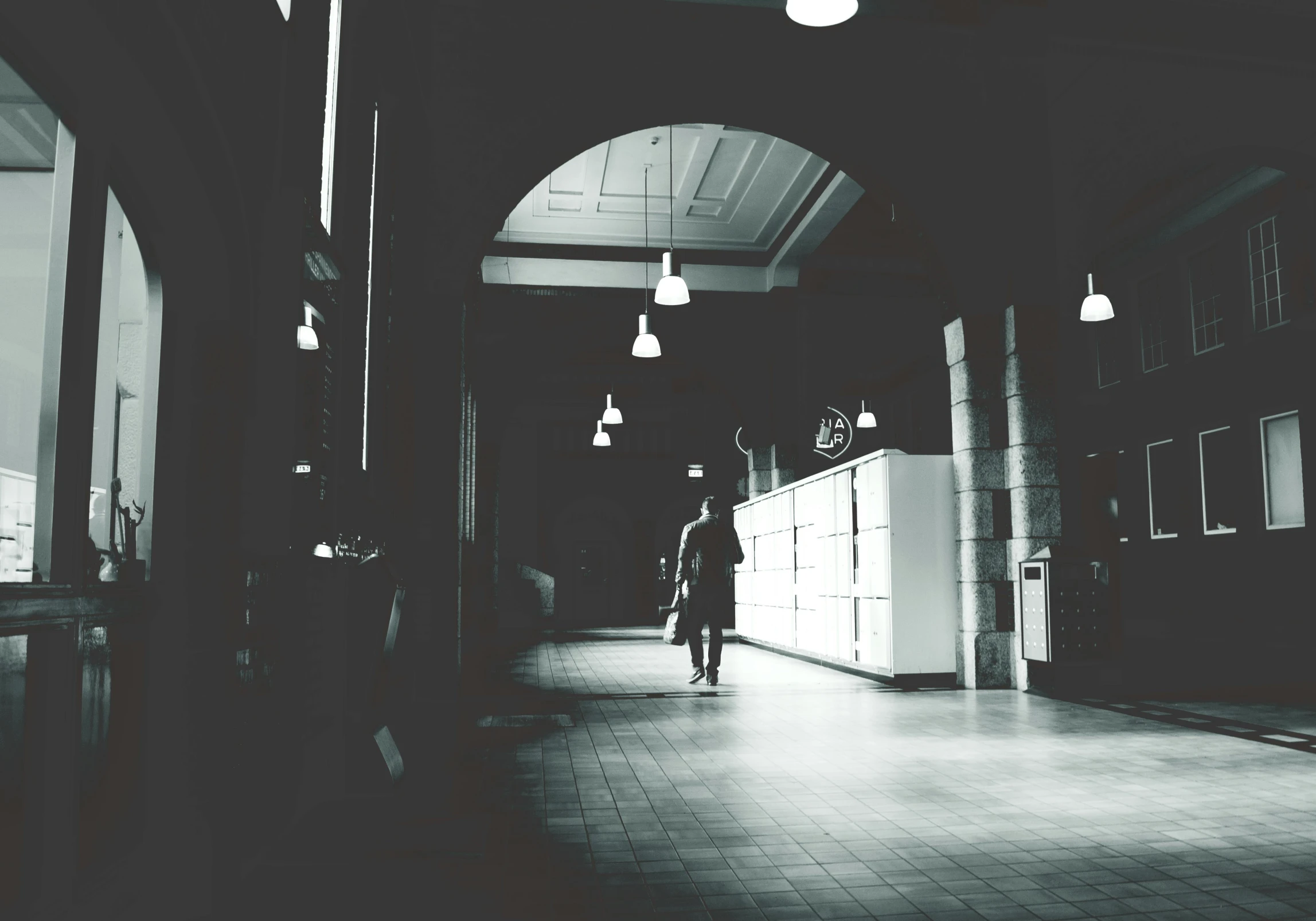 a hallway in a building with lights hanging from the ceiling