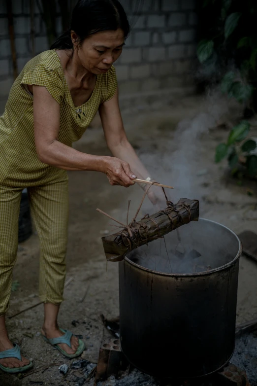 woman cooking food in an old style pot