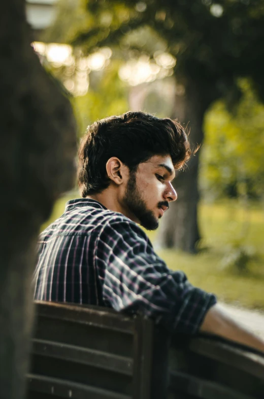 a man sitting on a bench with his eyes closed