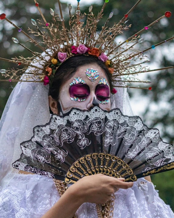 a woman with makeup holding an oriental fan