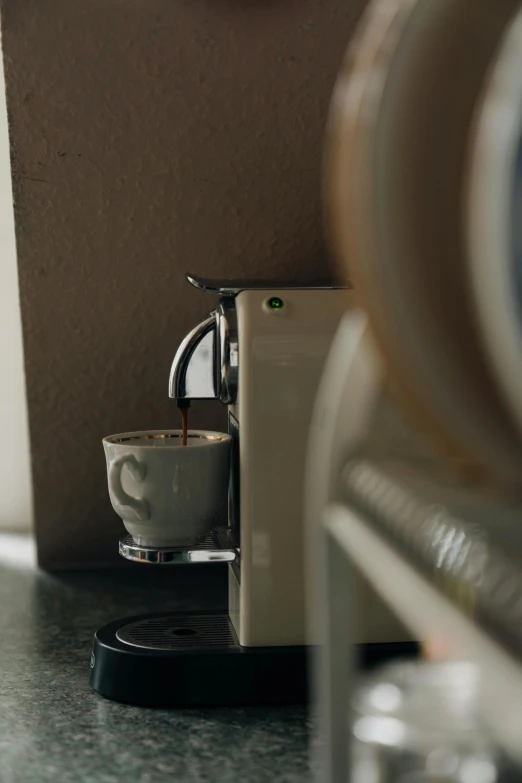 a close up of a coffee maker and cup