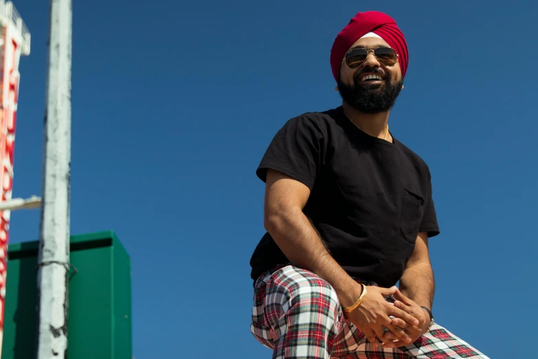 a man wearing a red turban and plaid pants