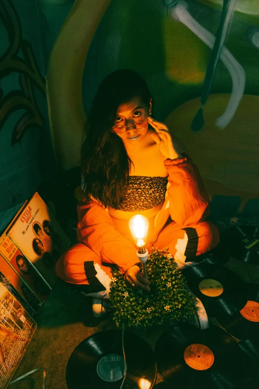 a woman with a candle on her knees, while listening to music