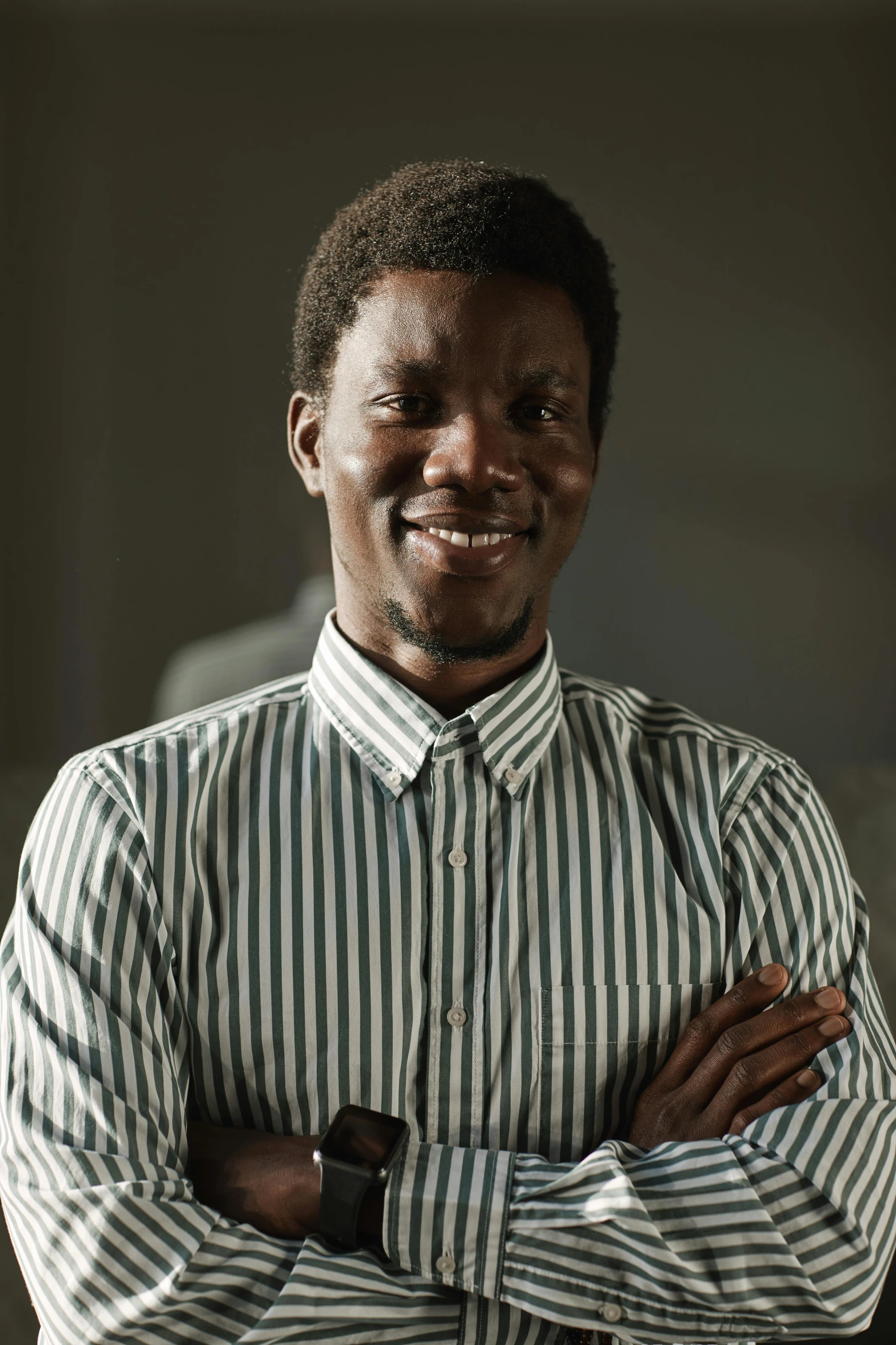 a man with his arms folded standing against the wall