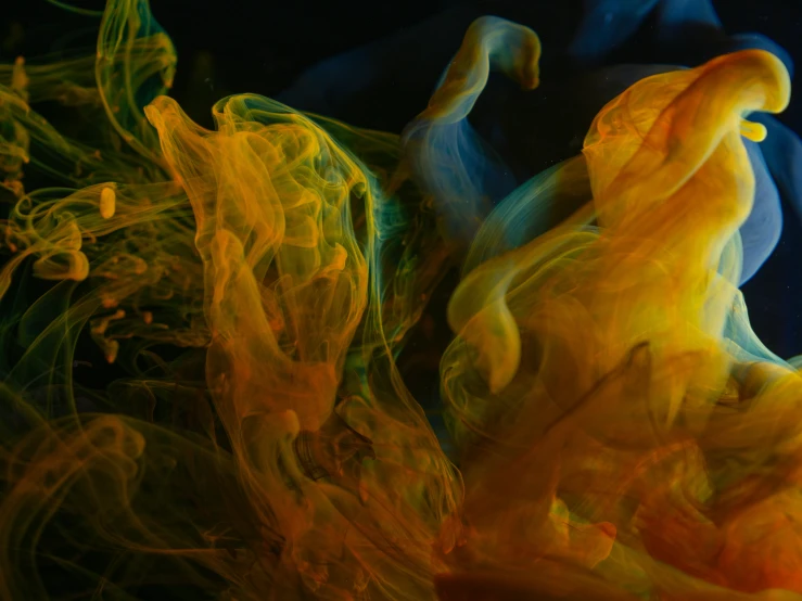 yellow and green smoke surrounds an orange and red object