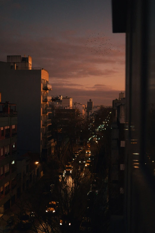 a nighttime view from inside a building looking over a street