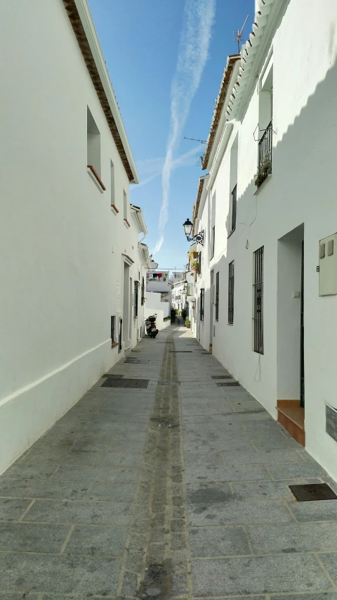 an empty street lined with buildings under a blue sky