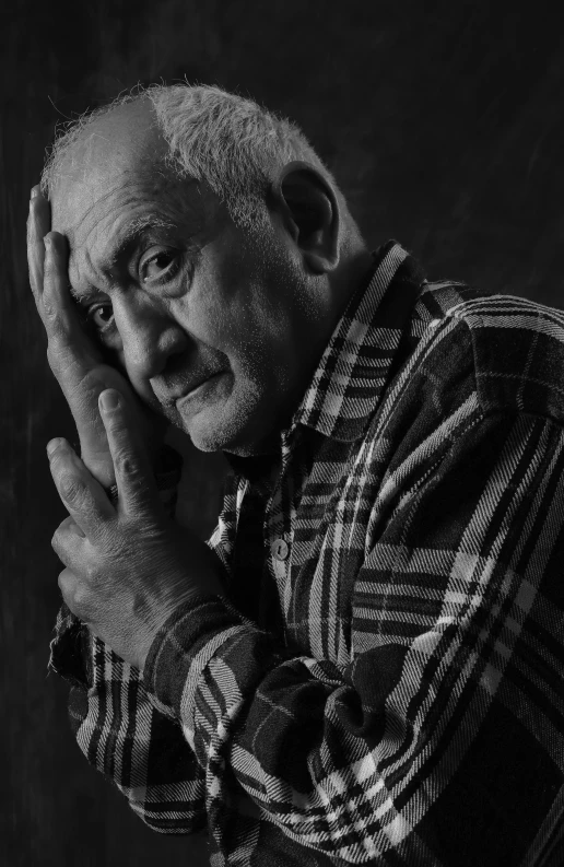 black and white portrait of an elderly man with hands clasped