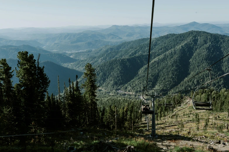 a scenic view of a green mountain range with a sky lift