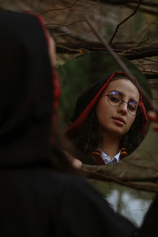 a woman in glasses looking at herself in the mirror