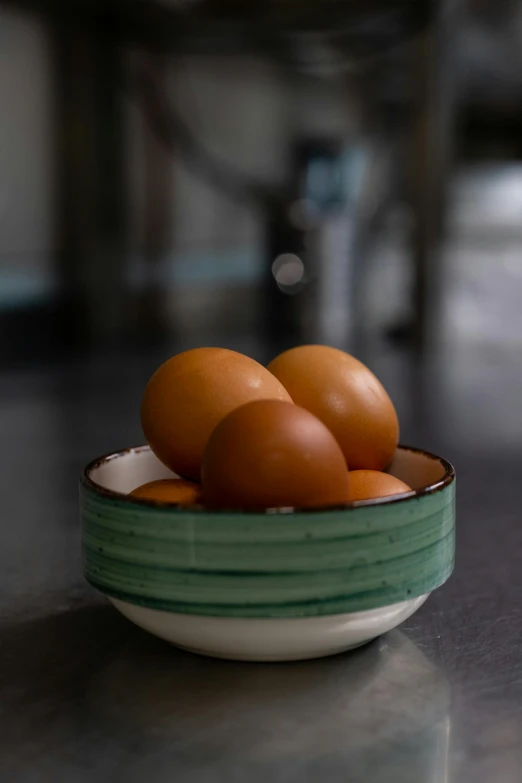 three eggs are in a green bowl on a table