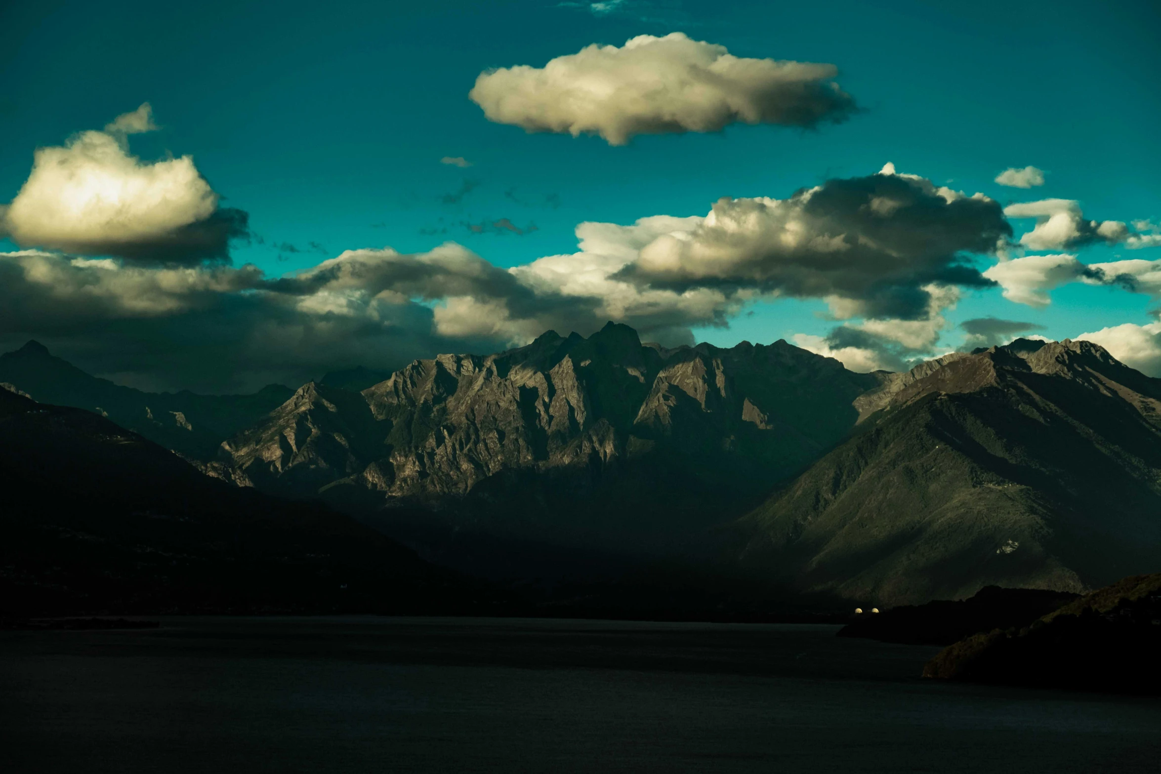 a dark po of mountains with a cloudy sky