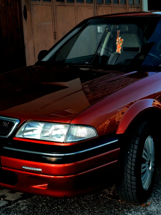 a maroon car parked in front of a brown door