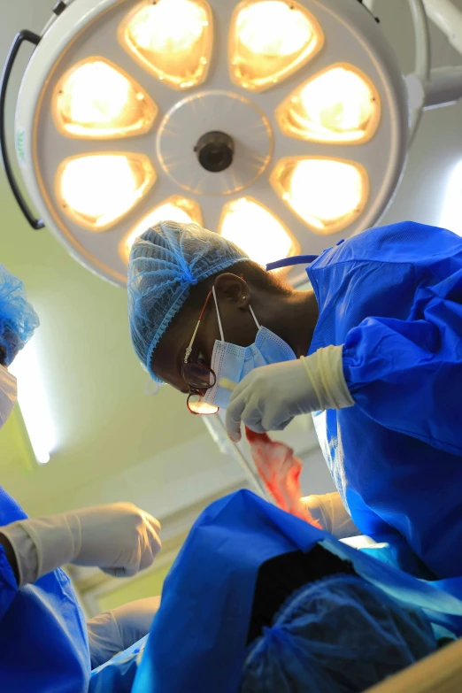 two surgeons perform  on a patient in an operating area