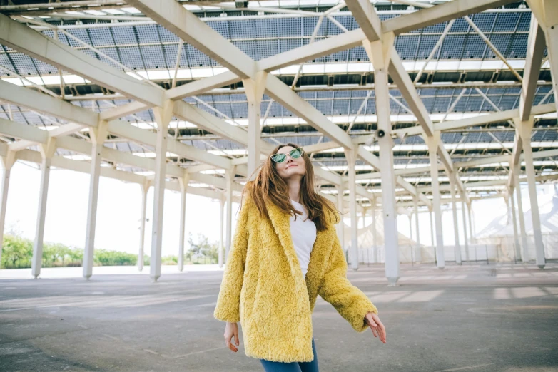 young woman standing with skateboard in outdoor space