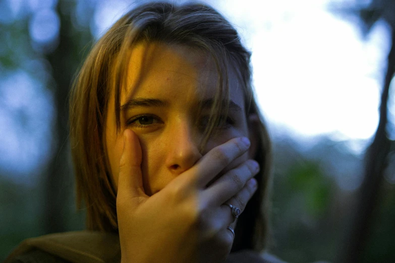 a woman is covering her nose with her hands