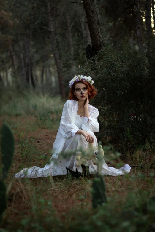 a woman sitting in the middle of the forest