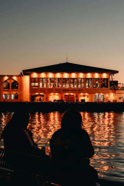 a couple of people that are sitting by the water